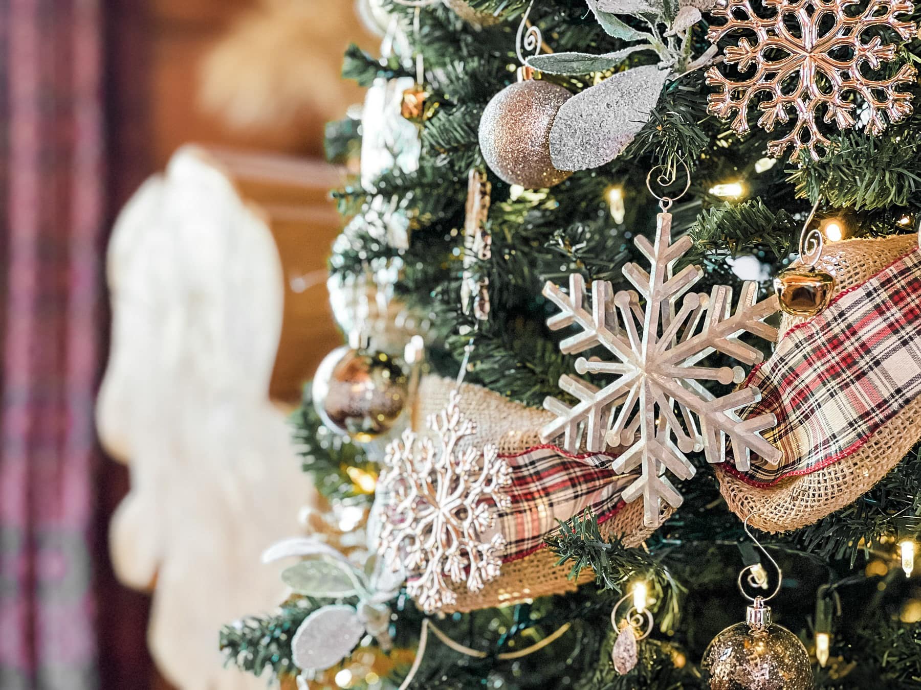 A rustic Christmas tree decorated with snowflakes.