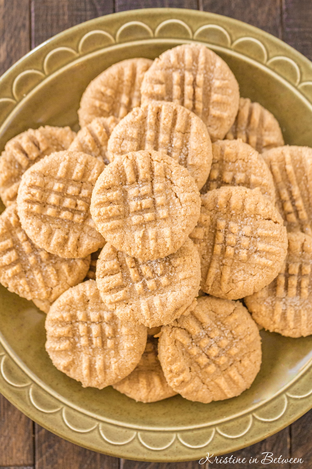A stack of peanut butter cookies on a green plate.