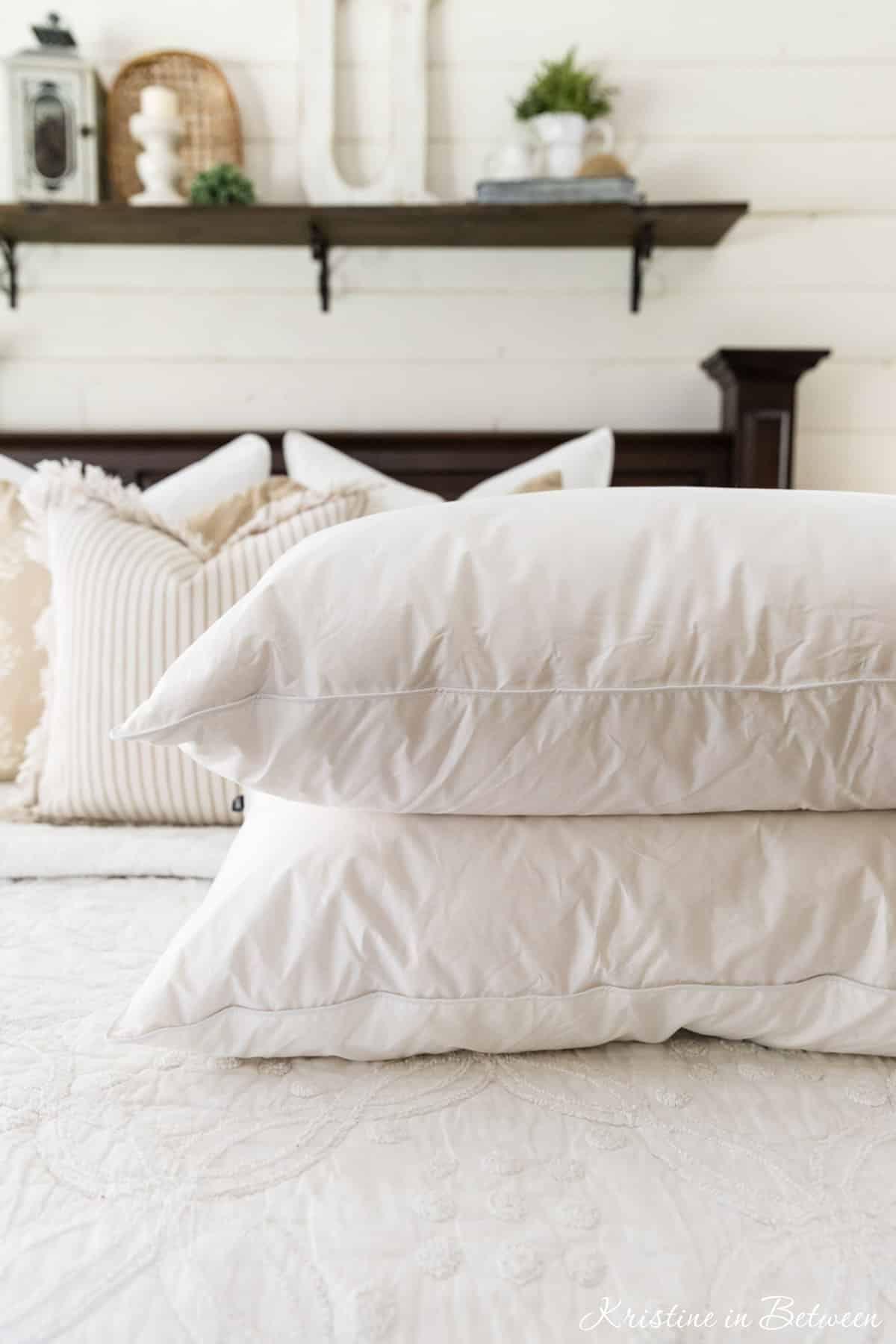 Two clean, stark white pillows sitting on a made bed.