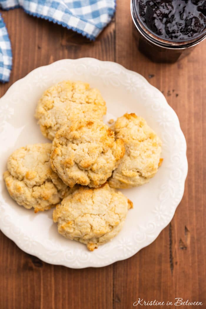 Several homemade old-fashioned drop biscuits on a white plate.