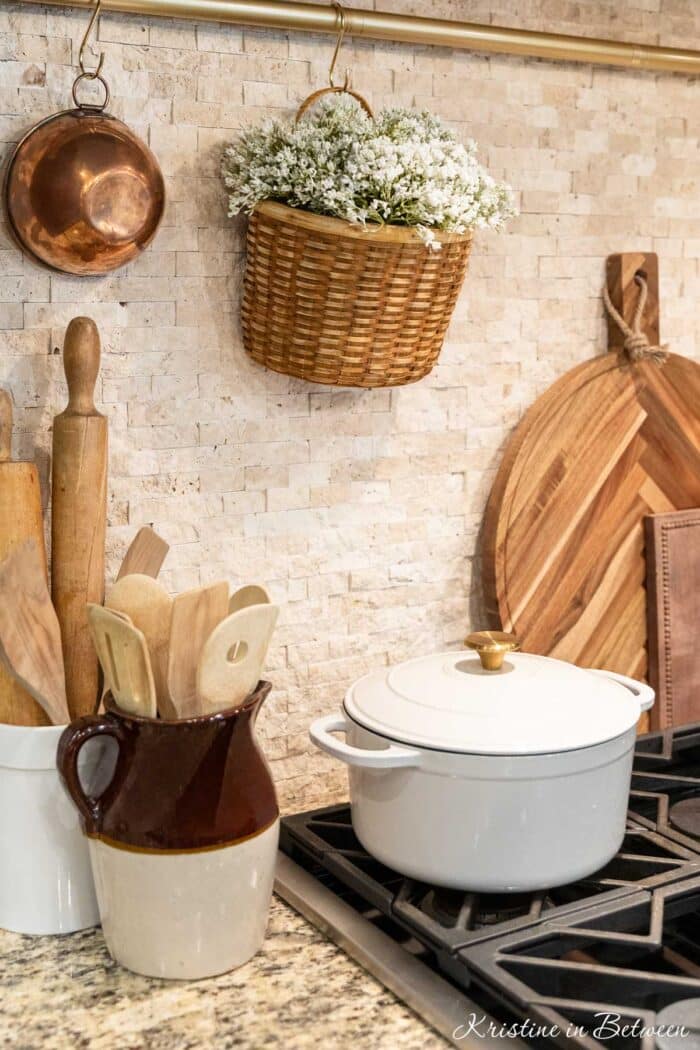 Cottage decor sitting on a kitchen counter with a kitchen rail behind the stove.