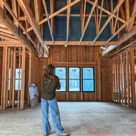 A woman facing one of her life transitions, standing in a framed house looking out three windows.