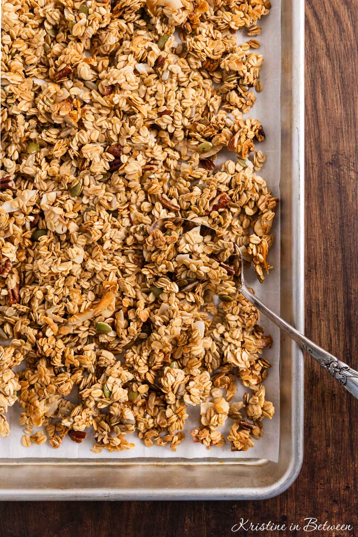 A pan of homemade granola with an antique spoon in it.