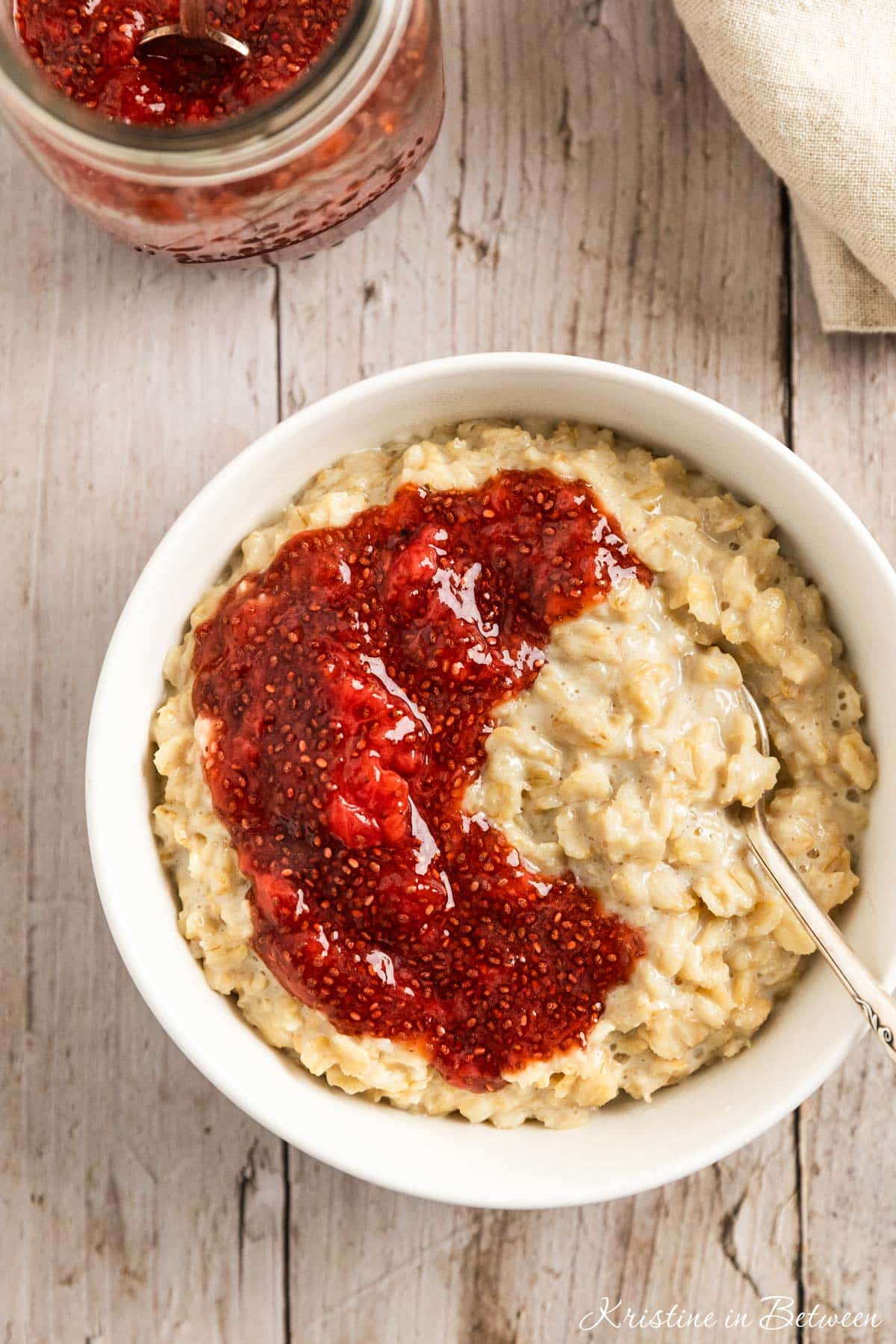 A bowl of oatmeal topped with homemade strawberry chia seed jam.