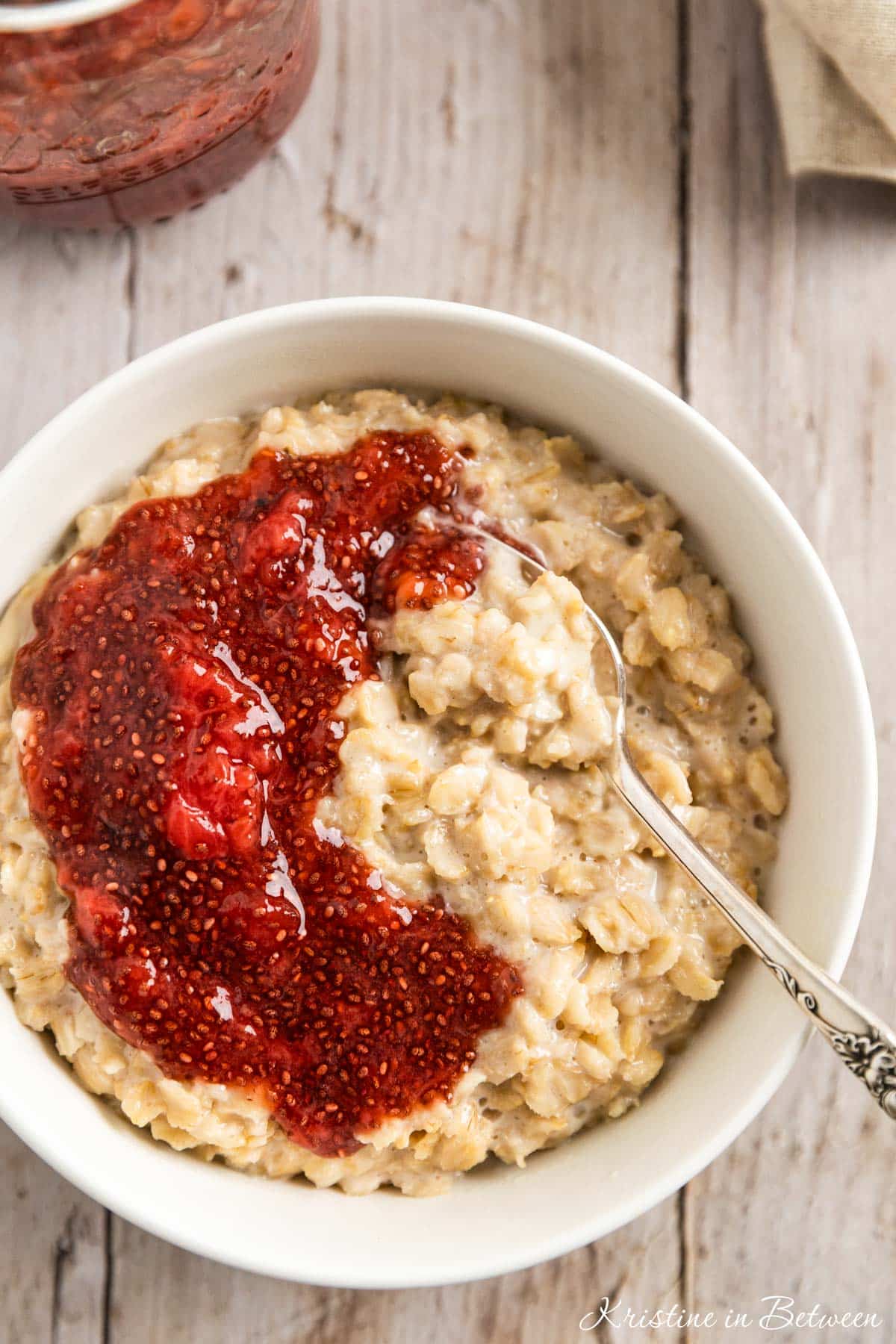 A bowl of oatmeal topped with homemade strawberry chia seed jam.