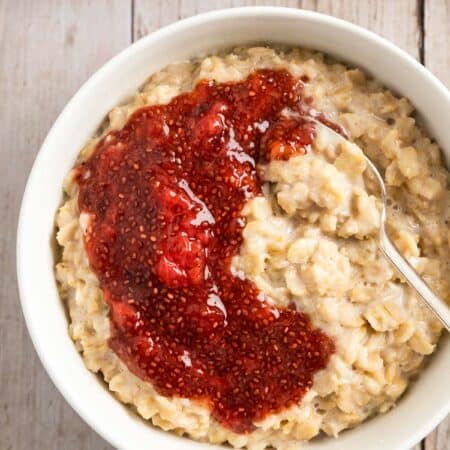 A bowl of oatmeal topped with homemade strawberry chia seed jam.
