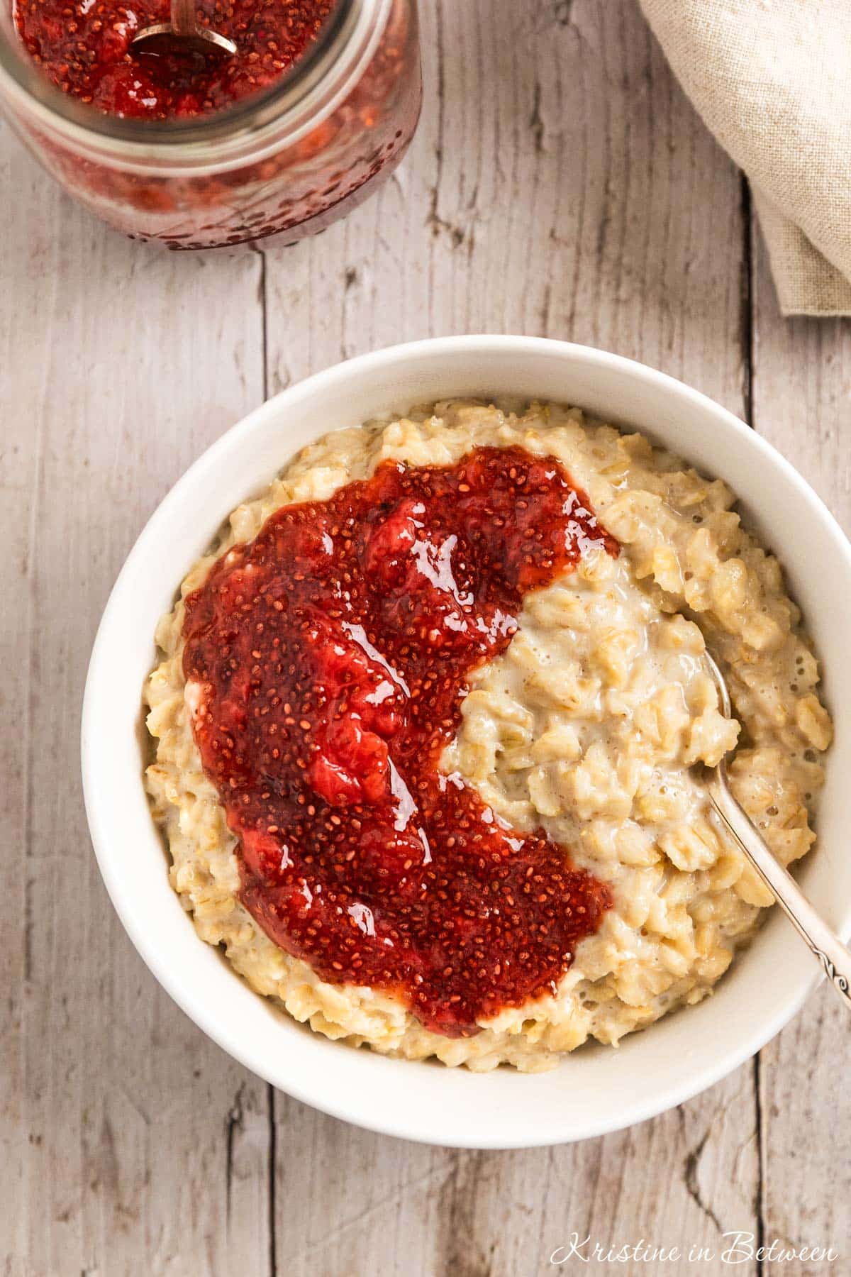 A bowl of oatmeal topped with homemade strawberry chia seed jam.
