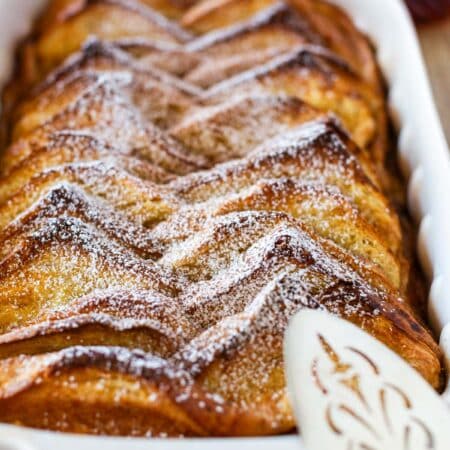 A pan of baked French toast with powdered sugar sprinkled on top.