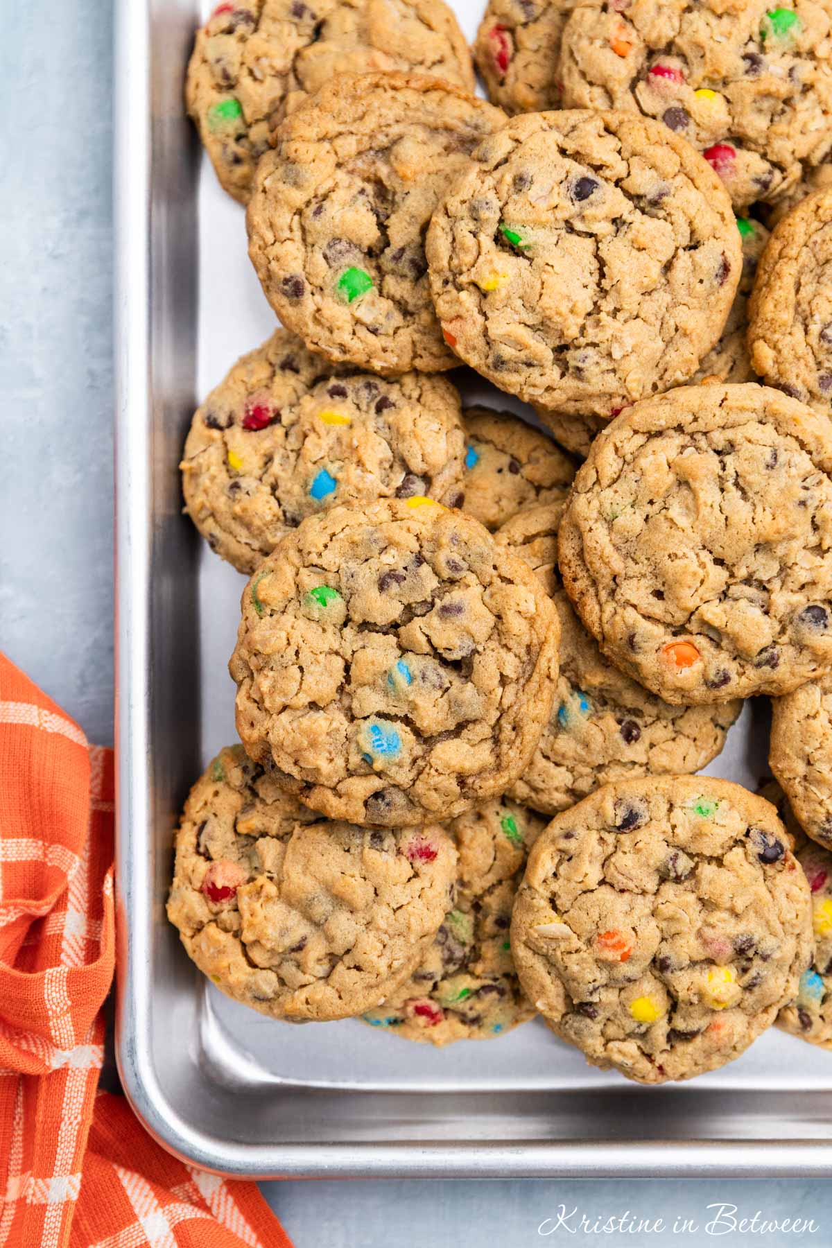 A whole tray of monster cookies sitting with an orange napkin.