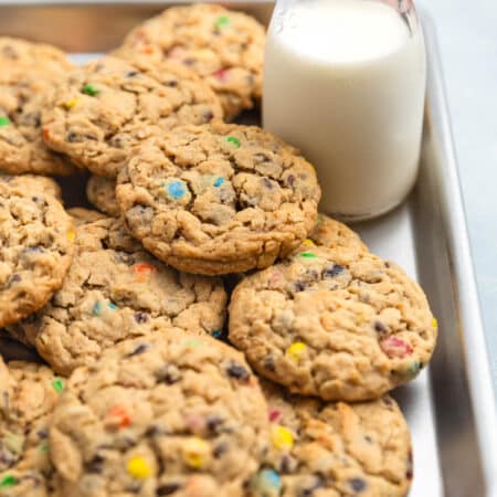 A whole tray of monster cookies sitting with an orange napkin.