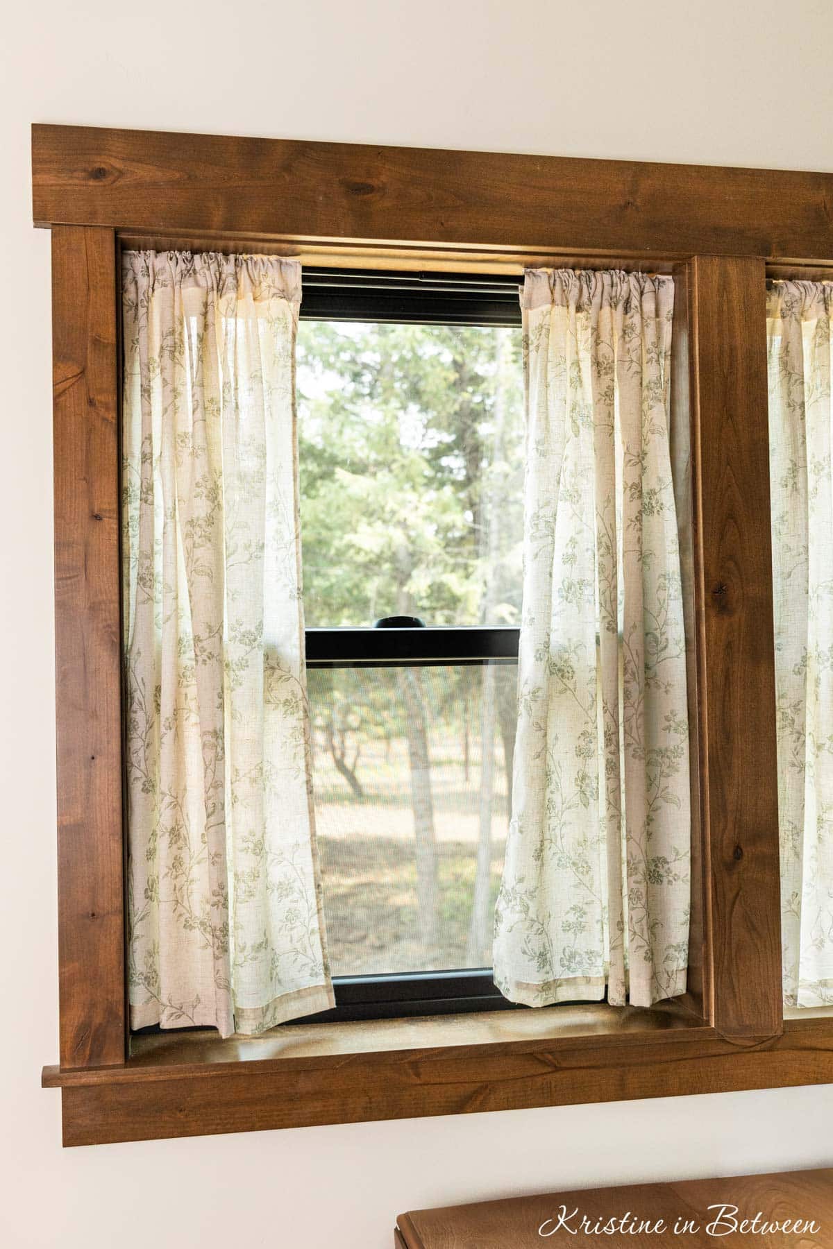 A window with linen curtains, open to the outside.