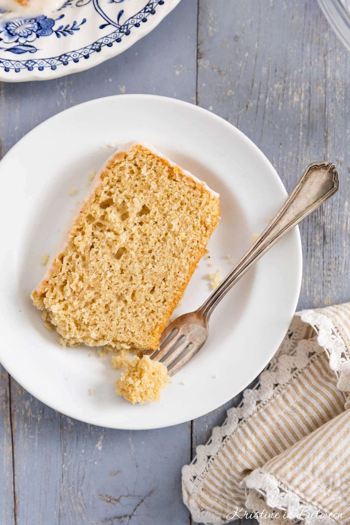 A slice of donut bread on a white plate with a bite on a fork.
