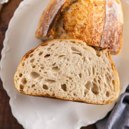 A loaf of sourdough bread cut in half to show the inside.