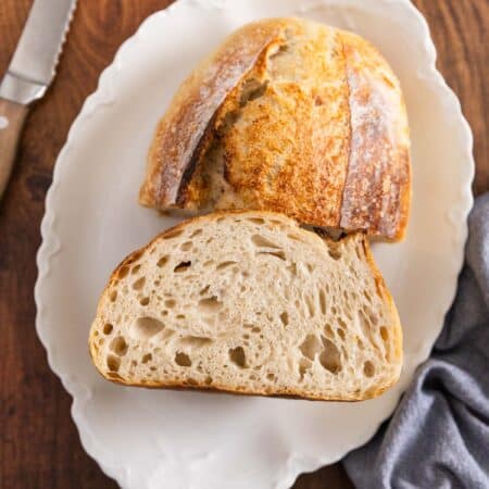 A loaf of sourdough bread cut in half to show the inside.